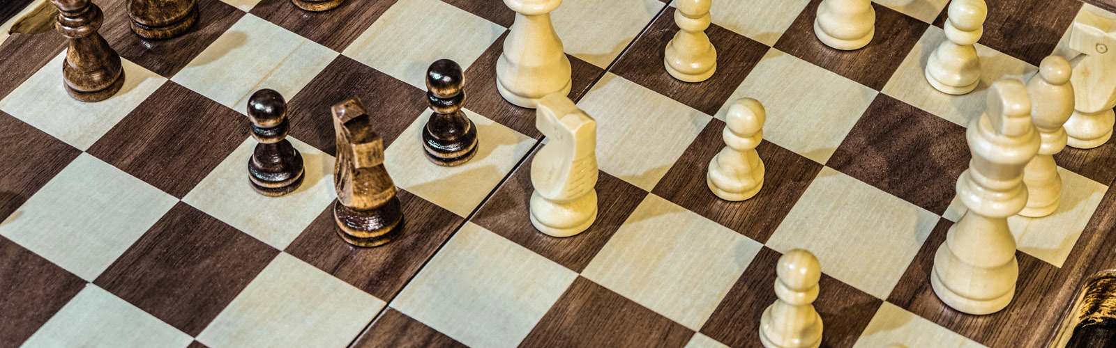 A close up picture of a chess board, with various pieces on it