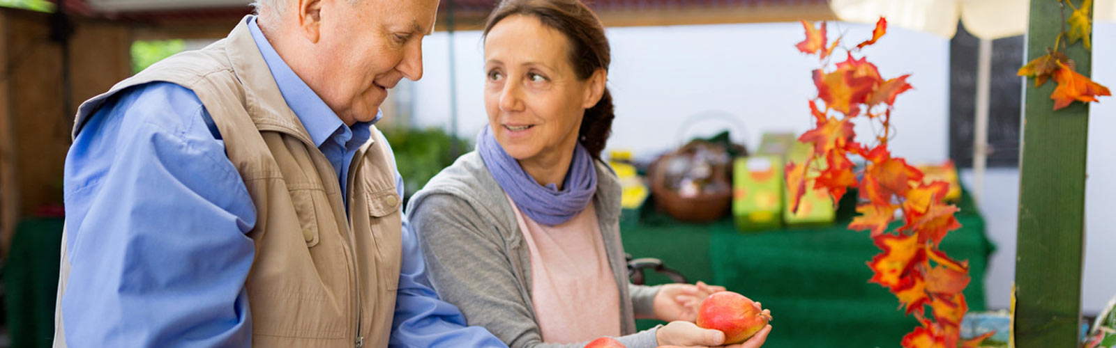 An older couple shop for fruit and veg