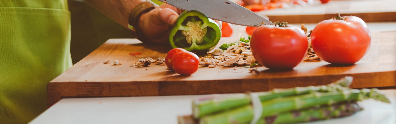 A knife slicing through a green pepper