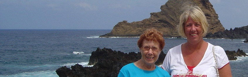 A mother and daughter smiling by the sea