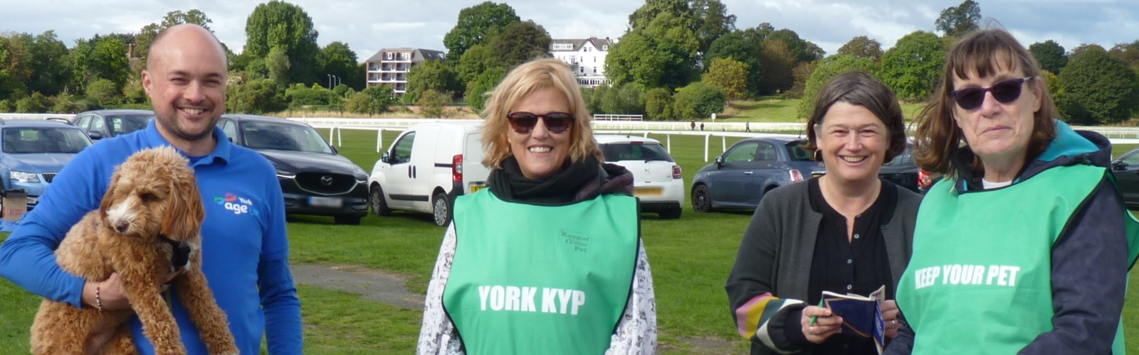 Two Age UK York team members, one holding a dog