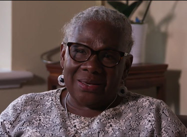 Lady with glasses sat in a chair being interviewed