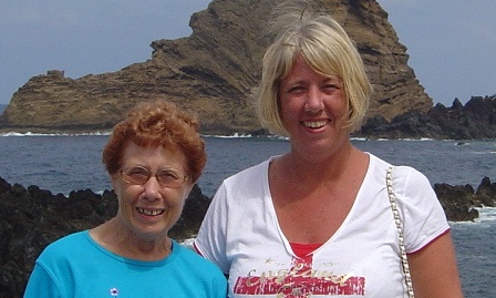 A mother and daughter smiling by the sea