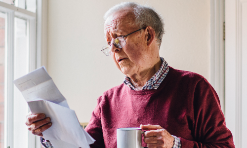 A  older man looking at a bill