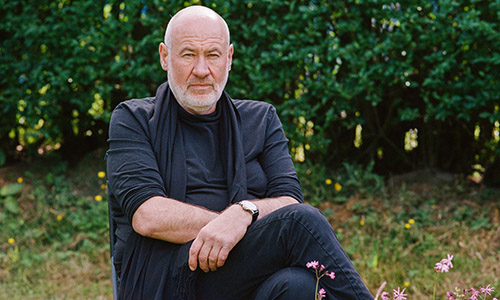 Musician Fish, wearing all black, sat in a garden.