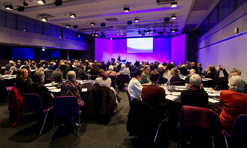 People sat at tables at Age UK's election rally