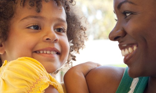 A mother and daughter smile at each other